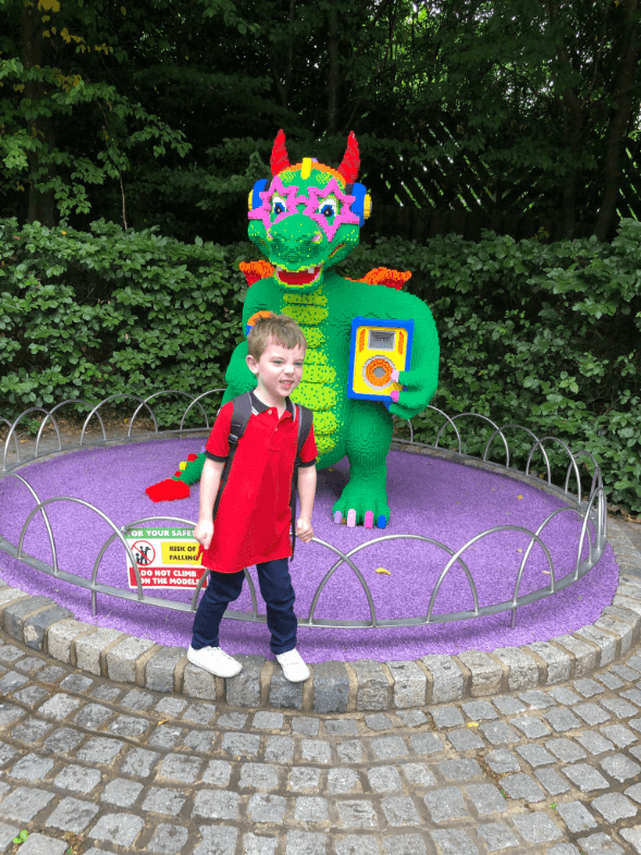 little-boy-at-legoland-standing-next-to-lego-dragon
